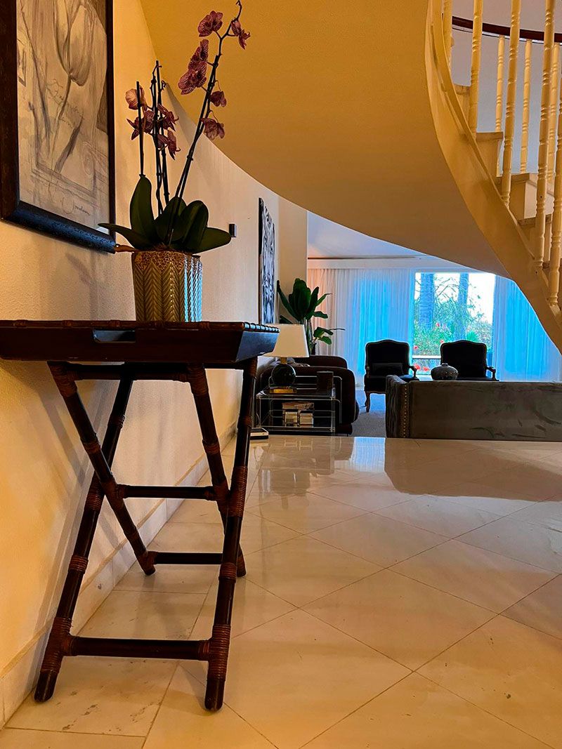 entrada de lujo con escaleras flotantes y ventanales panoramicos